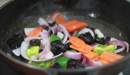 鍋中加入適量的油燒熱后，倒入切好洋蔥翻炒片刻，再
放入紅、青椒、胡蘿蔔，木耳炒至熟透為止；