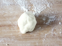 在案板上撒少許麵粉，將麵糰放到案上，用手揉均勻后，搓成長條，揪成一個個劑子后；