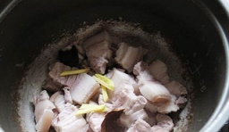 把煮好的五花肉倒入電飯煲中，放入乾淨的桂皮和切好薑絲；