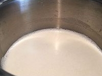 純牛奶和白砂糖混合后倒入鍋里用小火煮至白糖溶解；