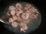 鍋里加適量的水煮開，把豬尾巴放進去氽燙，去血水和肥油后撈出；