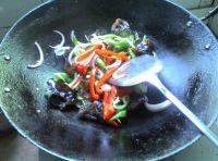 在鍋中加入適量的油燒熱后，放入切絲洋蔥、木耳和青紅椒翻炒均勻后，盛出；
    