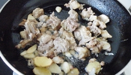 在另一油鍋里，煸香薑片、豬肉丁至變色；
