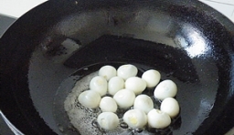 鍋內倒油燒熱，把鵪鶉蛋去殼後放入炸至金黃撈出；