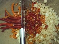 辣椒和大蒜瓣洗凈后切碎，放入碗中；