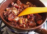 鍋內倒入花生油燒熱，把牛肉粒倒進去翻炒至變色后盛出；