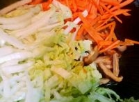 炒香后，加入切絲的白菜，胡蘿蔔和香菇，翻炒片刻；