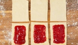 切成相等的矩形，在矩形麵皮上抹上草莓果醬；