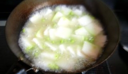 鍋中留有少許的底油，放入切片的冬瓜，炒1分鐘左右後，倒入毛豆后，加入適量的水，用大火煮到冬瓜略熟為止；
