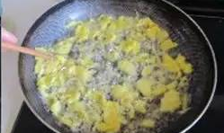 鍋內再放點油，把蛋黃液放進去用筷子攪拌拉絲；