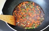 鍋里留有少許油燒熱后，倒入切碎的胡蘿蔔和蒜苔丁翻炒片刻后，再放入蔥花爆香后，再加入調好的料汁，用小火加熱；
