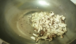 另起油鍋燒熱，放入姜沫和蒜沫炒香后，放入香菇並炒軟；
