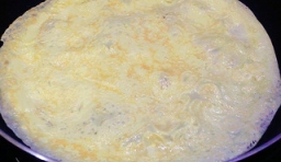 油鍋燒熱，倒入攪拌好的蛋液，讓蛋液平攤再鍋底；