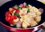 加入切好紅、青椒和玉子豆腐，倒入調好的料汁，晃動一下炒鍋，讓混合均勻后再盛出；
