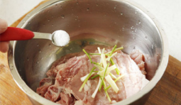 剁好的豬大排放入空器中，加入蔥段、鹽和適料酒腌上30分鐘；