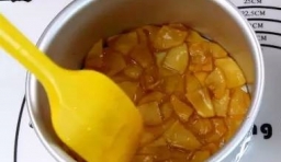 把切片的蘋果倒進去用中火煮至蘋果變軟並上色，汁變粘稠后加入黃油攪拌均勻；