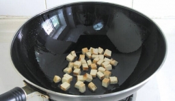 炒鍋燒中加入適量的油燒熱，倒入切好的豆腐丁，用大火煸炒1分鐘，直到鍋中豆腐丁表面呈微黃色；
