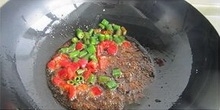 在熱鍋倒入適量的調和油，等到鍋中的燒熱時，倒入辣椒醬要炒出香味，再加入切丁青紅辣椒炒出辣味來；
