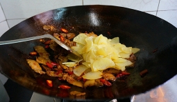 燒熱炒鍋，加入適量的食用油，待油熱后，倒入控干水分的土豆片，用小火炸至；
