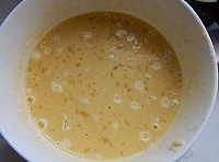 乾淨的碗中加入適量的麵粉，打入雞蛋后，再加入鹽和五香粉攪拌均勻麵糊；

