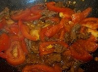 接下來倒入切片的番茄，炒出汁水兒並化掉一部分的時，再倒入適量的熱水；
