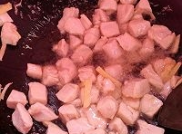 熱鍋中加入適量油，待油熱后，下入腌至好的雞丁，快速滑炒至發白，盛出；
