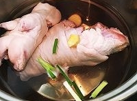 將豬蹄處理乾淨，放入冷水鍋中，加入蔥段和薑片一起煮；
