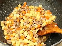 加入土豆丁和胡蘿蔔丁翻炒一會兒后，放入適量的醬油、五香粉、鹽翻炒均勻；

