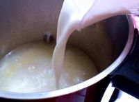黃豆連煮的水一起倒進豆漿機里，水離水位線不要太緊，再倒入半盒純牛奶開始打豆漿；