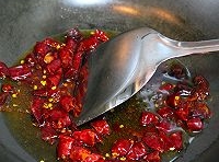 鍋中留有少許的底油，加入紅辣椒段和花椒粒煸炒，放入蔥姜蒜末煸炒出香味；