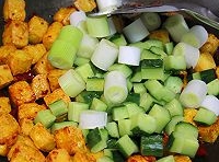 炒出香味后，放入豆腐塊翻炒數秒，倒入切好的黃瓜丁、蔥段翻炒均勻；