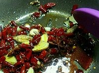 鍋中留有少許的底油，倒入干辣椒、花椒粒、薑片和蒜片，炒出香味；
