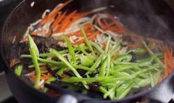 等到鍋中的食材變軟后，放入青椒絲和木耳絲， 翻炒片刻后，再撈出，控干油分；
