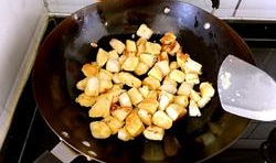 熱鍋中加入適量的油，燒熱后，放入饅頭丁，用小火煎至饅頭丁表面金黃，盛出；
