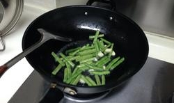 鍋內放油燒熱，炒香大蒜，再放入豆角炒至變色后把茄子放入翻炒；