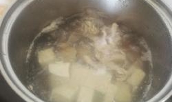 鍋中加入適量的水，燒開后，下入入豆腐塊、瘦肉絲、和花蛤煮開；