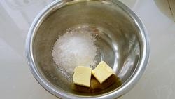 將黃油提前軟化，加入適量的糖粉，攪拌均勻后，稍微打發；