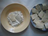 把豆腐片的兩面均勻的沾滿干澱粉；